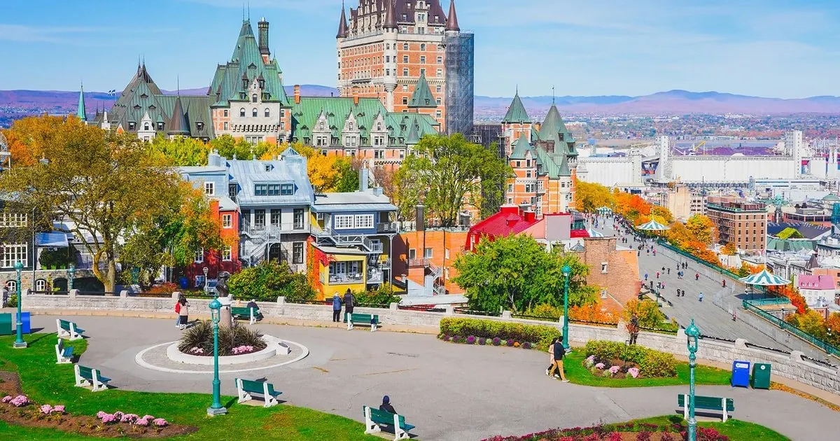 Old Québec in autumn with the Château Frontenac above a square and trees in red and orange